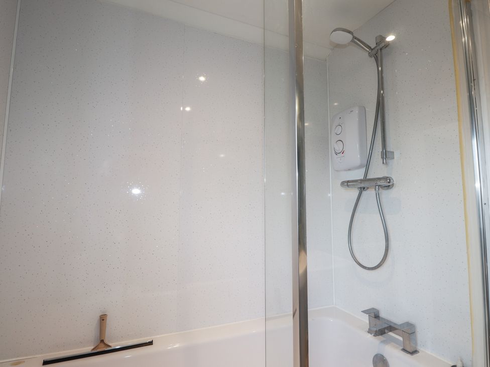 A bathroom with a shower and bath faucet at Free Presbyterian Manse in Kinlochbervie