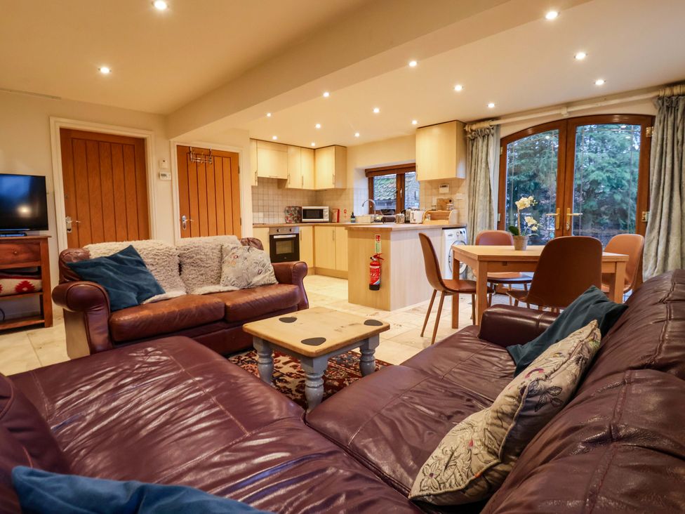 A living room with a sofa and dining area at Brush and Boot in York