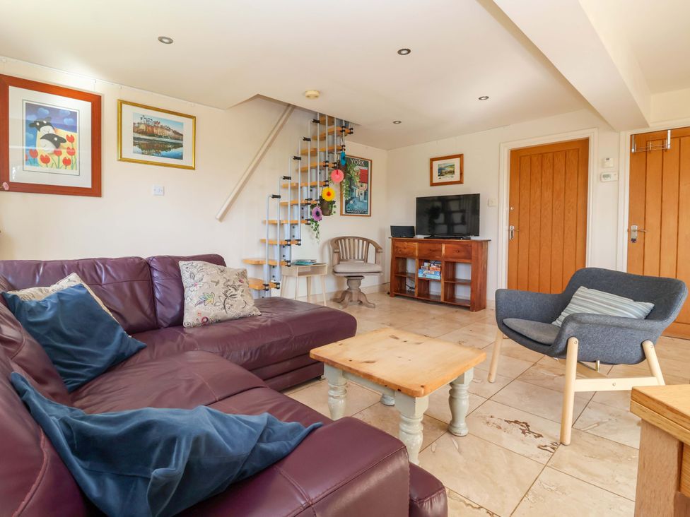 A living room with a sofa and staircase at Brush and Boot in Stittenham near York
