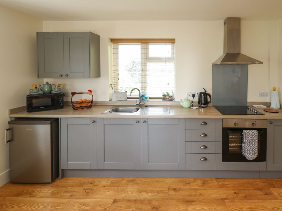 A kitchen with cabinets, sink, stove, microwave, and fruit bowl at The New Build in South Reston near Louth