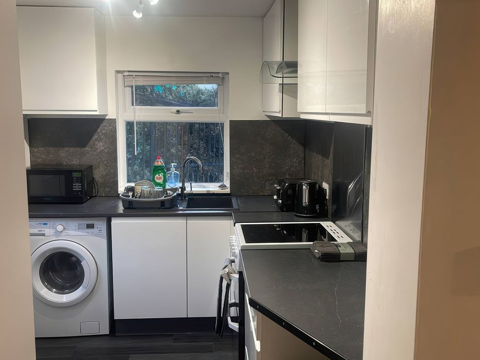 A kitchen with appliances including a microwave and washing machine at Solway Firth View in Powfoot near Annan