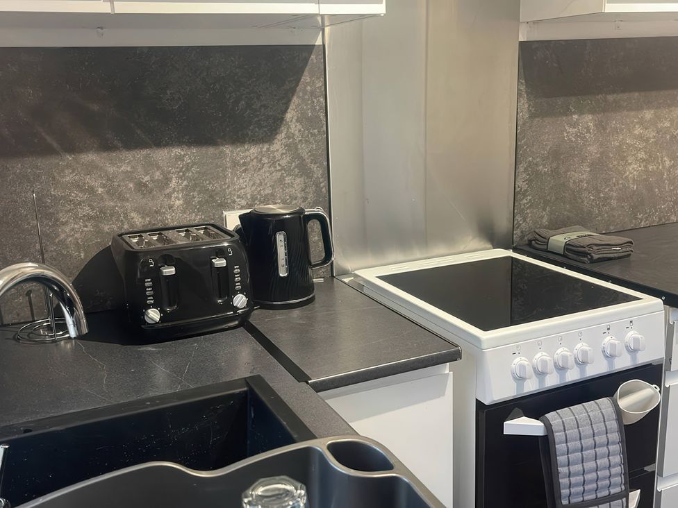 A kitchen with a sink, kettle, toaster, and stove at Solway Firth View Powfoot near Annan