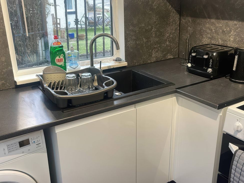 A kitchen with a sink, dish rack, and toaster at Solway Firth View Powfoot near Annan