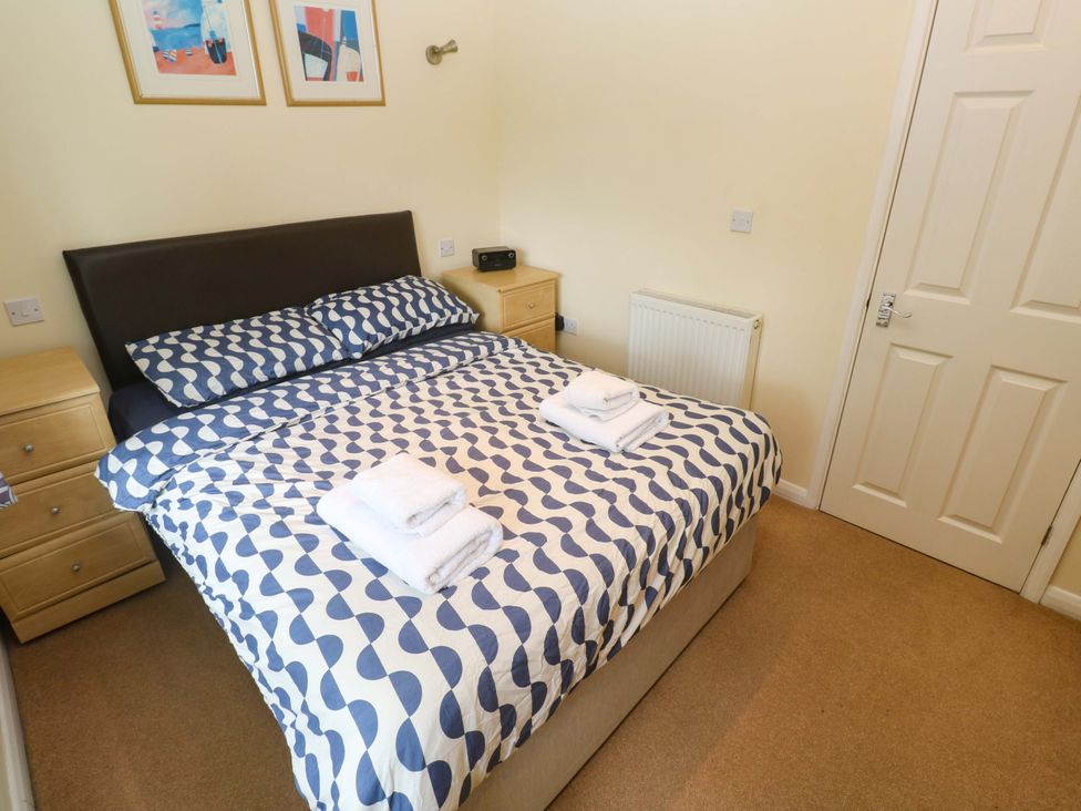 A bedroom with a bed, bedside table, and towels at 87 Atlantic Reach in Indian Queens