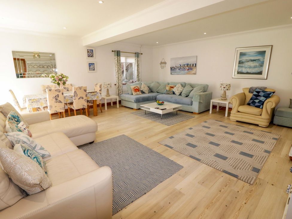 A living room with sofas and a dining area at Charlecote House in Saundersfoot