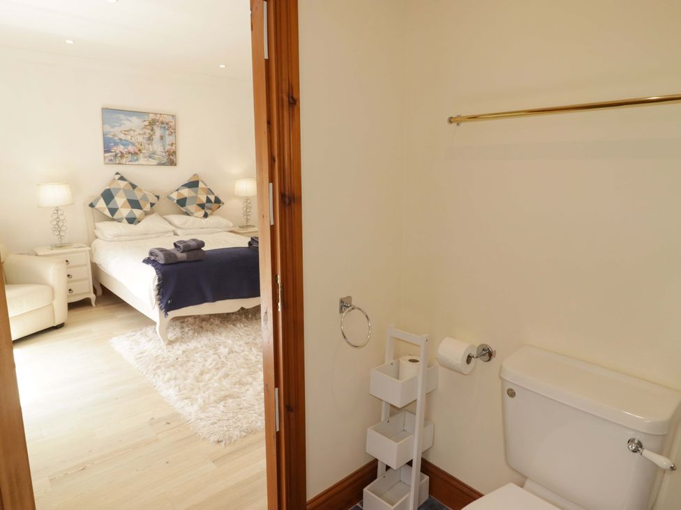 A bedroom with a bed and a bathroom with a toilet at Charlecote House in Saundersfoot