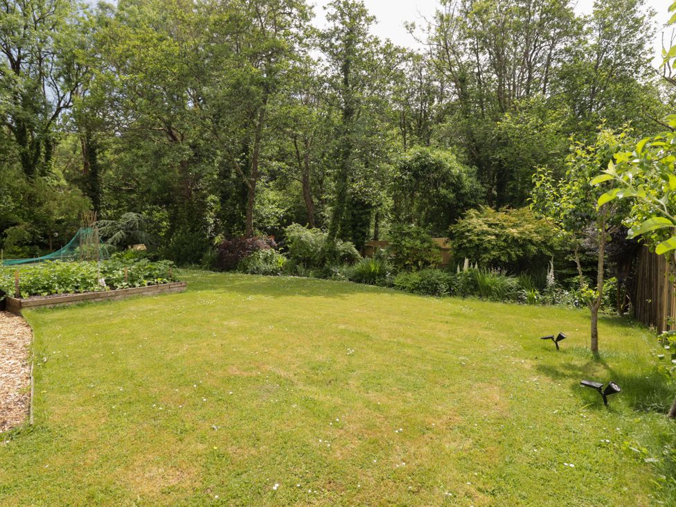 A garden with grass and trees at Charlecote House in Saundersfoot