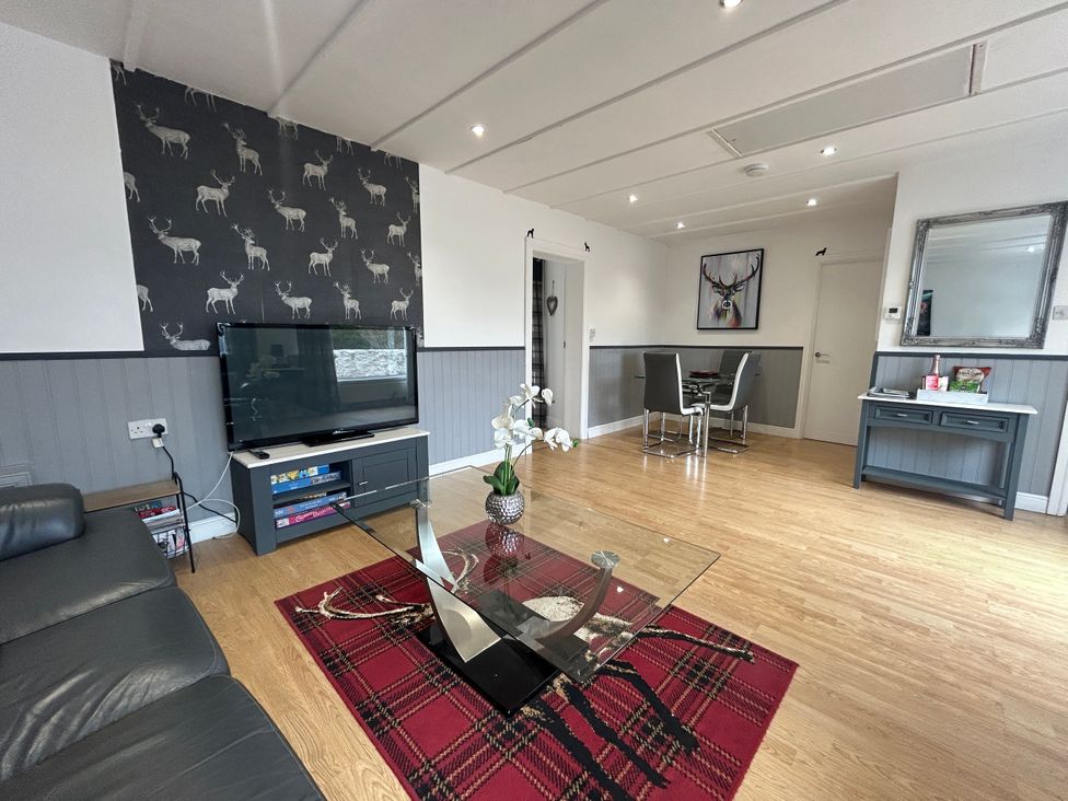 A living room with a coffee table and television at Solway Cottage Powfoot near Annan