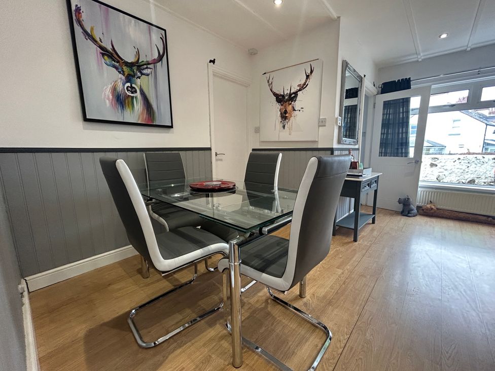 A dining room with a glass table and chairs at Solway Cottage Powfoot near Annan