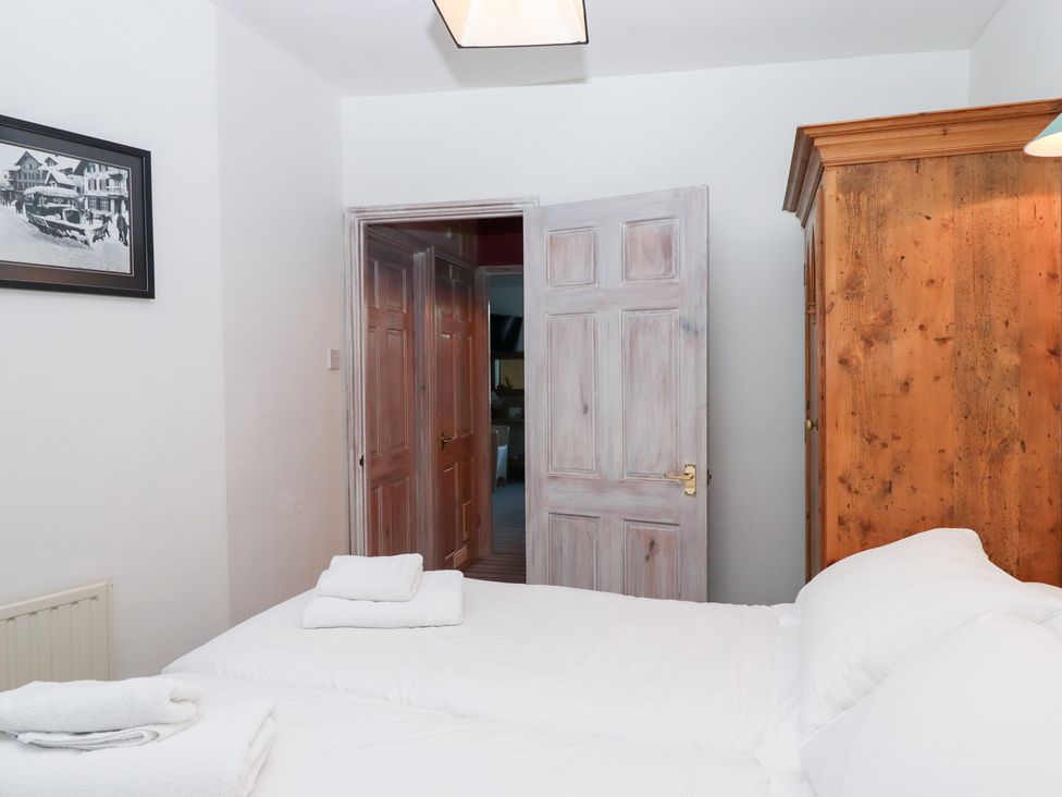 A bedroom with a wardrobe and towels on a bed at 13 Above Town in Dartmouth