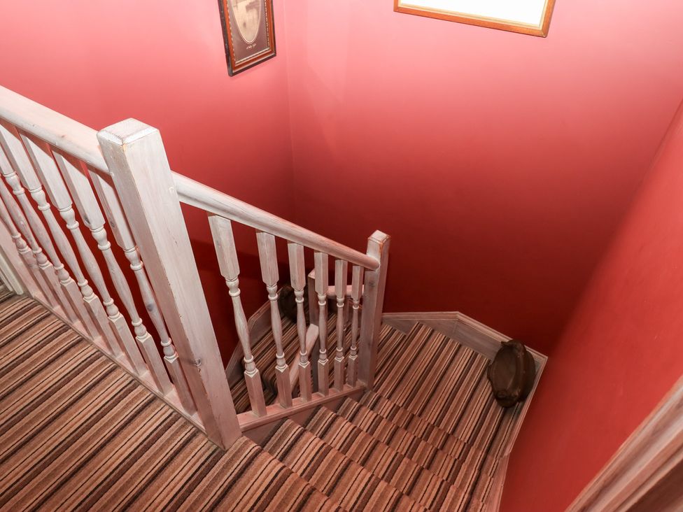 A staircase with a balustrade and patterned carpet at 13 Above Town in Dartmouth
