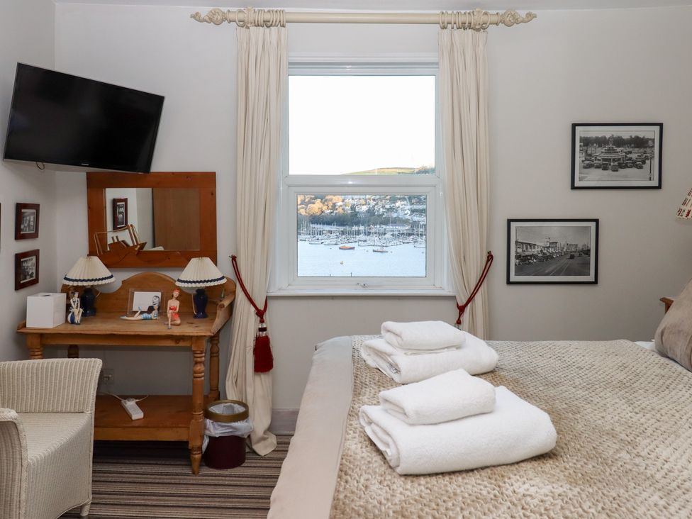 A bedroom with a bed, mirror, and television at 13 Above Town in Dartmouth
