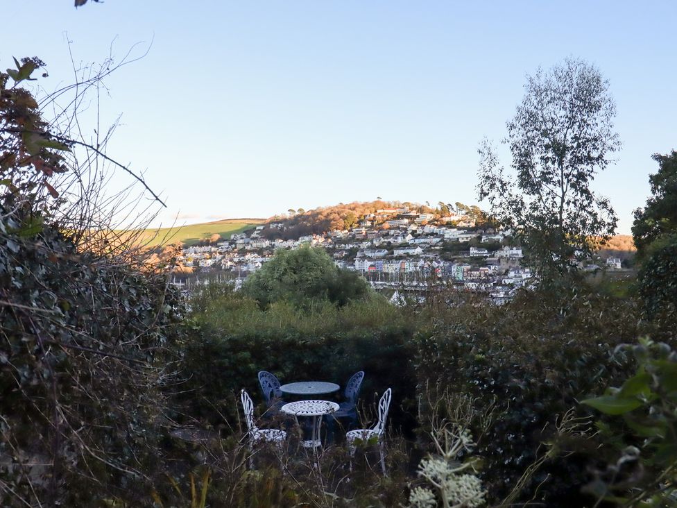 A garden with a table and chairs overlooking houses at 13 Above Town in Dartmouth