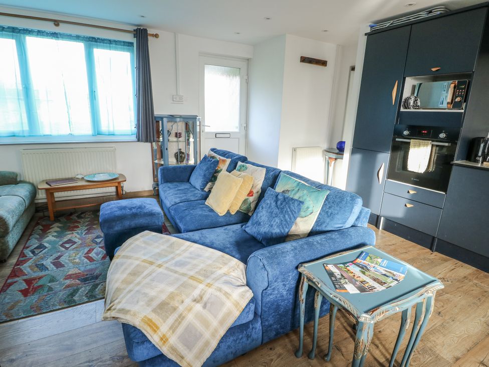 A living room with a blue sofa and coffee table at 7 Bro Branwen Aberffraw near Rhosneigr