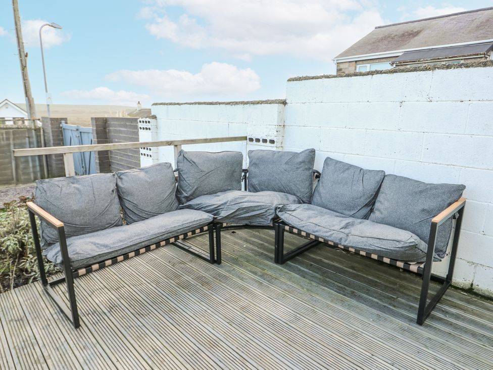 A sofa with cushions in a garden at 7 Bro Branwen Aberffraw near Rhosneigr
