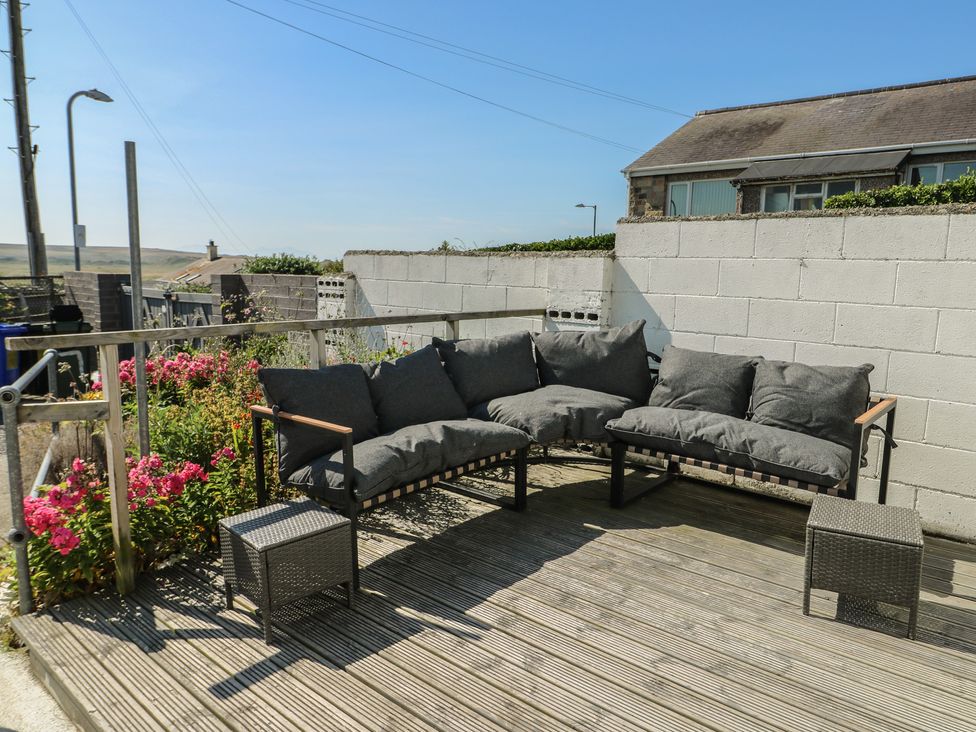 An outdoor area with a sofa and flowers at 7 Bro Branwen Aberffraw near Rhosneigr