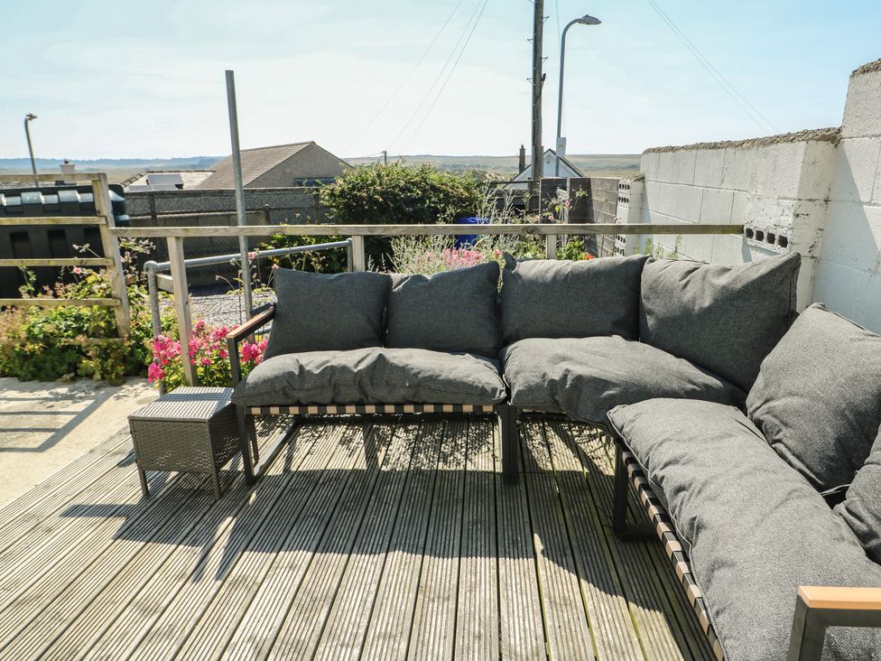 An outdoor seating area with cushions and a small table at 7 Bro Branwen Aberffraw near Rhosneigr
