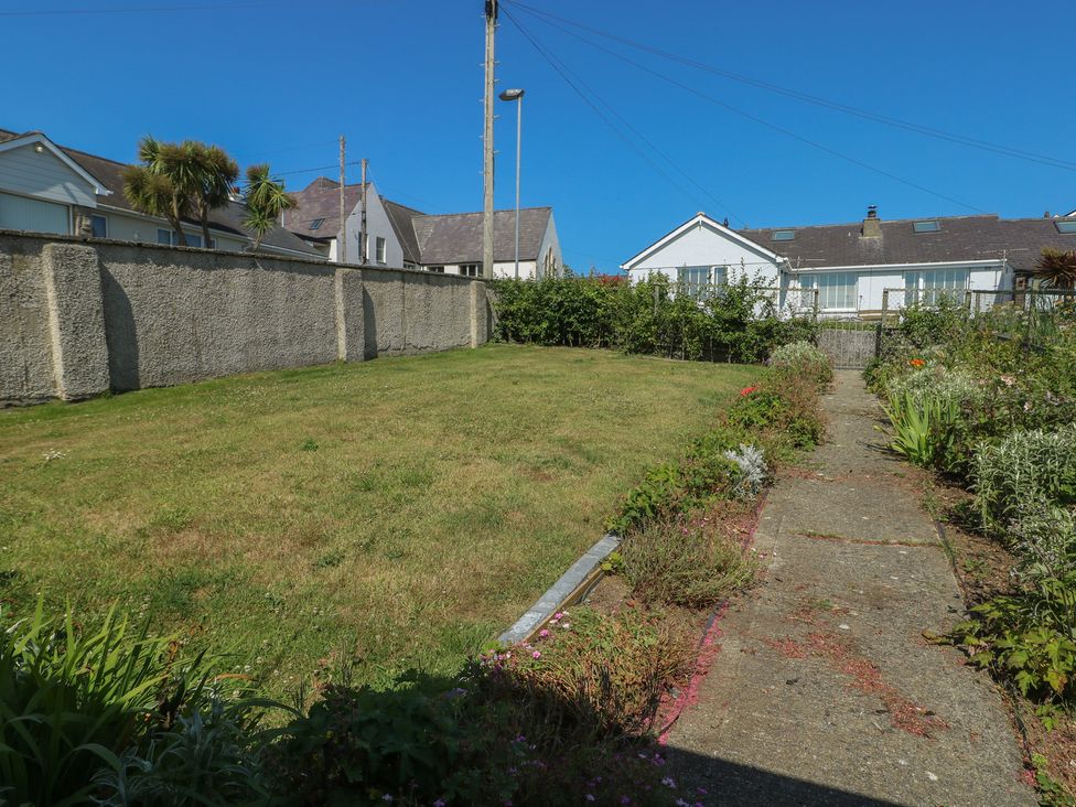 A garden with grass and flower bed at 7 Bro Branwen Aberffraw near Rhosneigr