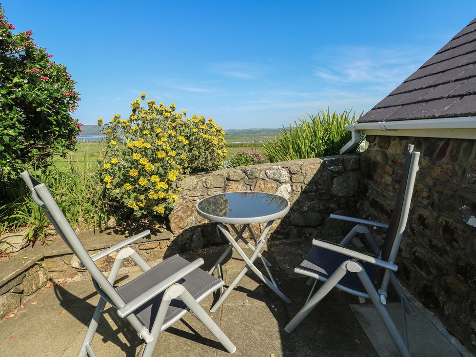 An outdoor space with chairs and a table at Sunstone (Garreg Haul) Cilan near Abersoch