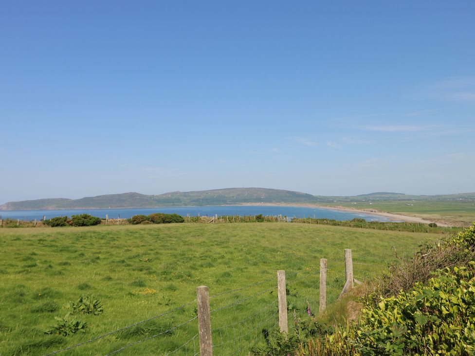 A view of the sea and hills from a grassy area at Sunstone (Garreg Haul) Cilan near Abersoch