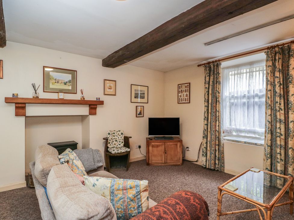 A living room with a sofa and television at Dollar Ward House Basement Cirencester