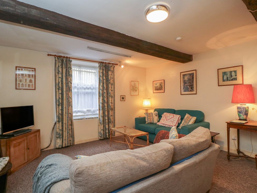 A living room with a television, sofa, and artworks at Dollar Ward House Basement Cirencester