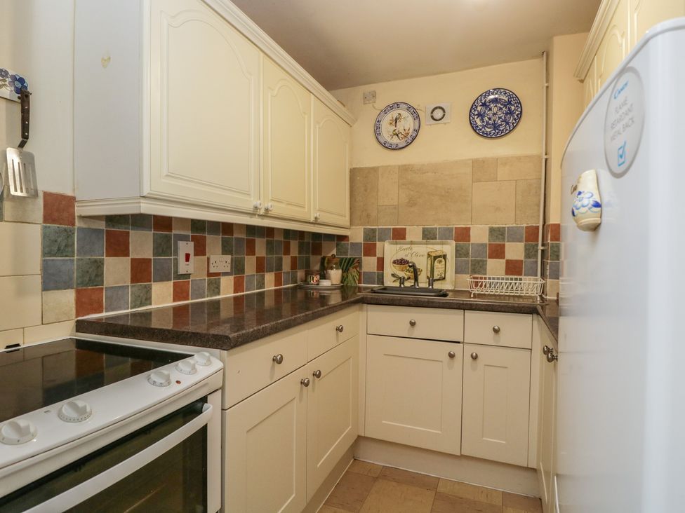 A kitchen with cabinets and appliances at Dollar Ward House Basement Cirencester