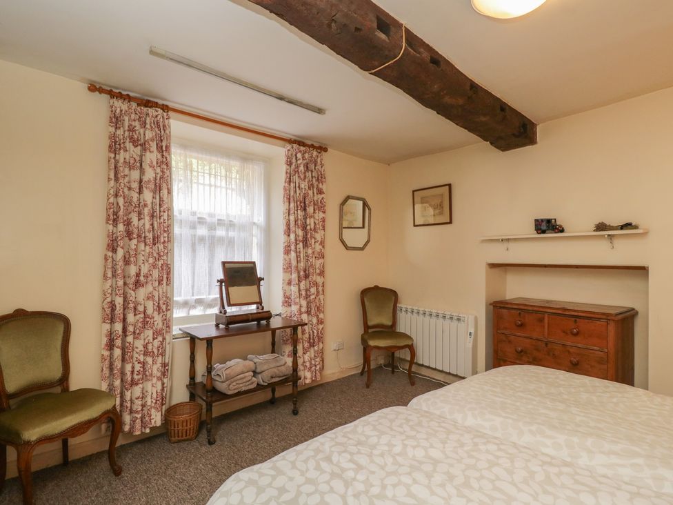A bedroom with a bed, dressing table and window at Dollar Ward House Basement Cirencester