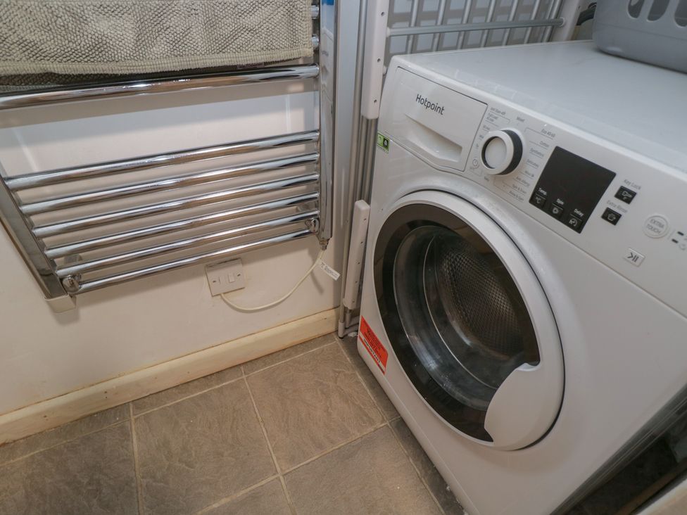 A laundry room with a washing machine and a towel rail at Dollar Ward House Basement Cirencester