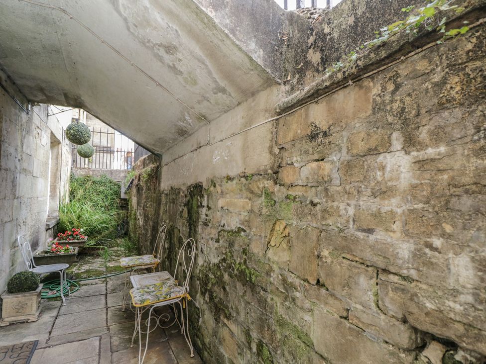 A garden area with stone walls and outdoor seating at Dollar Ward House Basement Cirencester