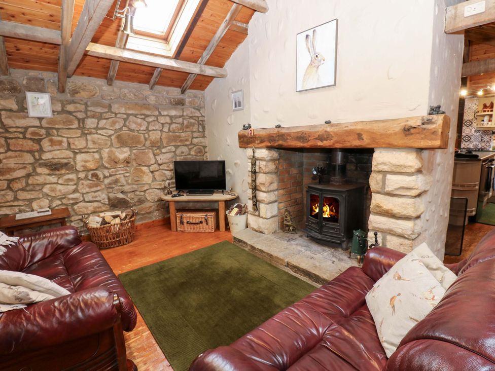 A living room with a fireplace and television at The Granary in Rothbury
