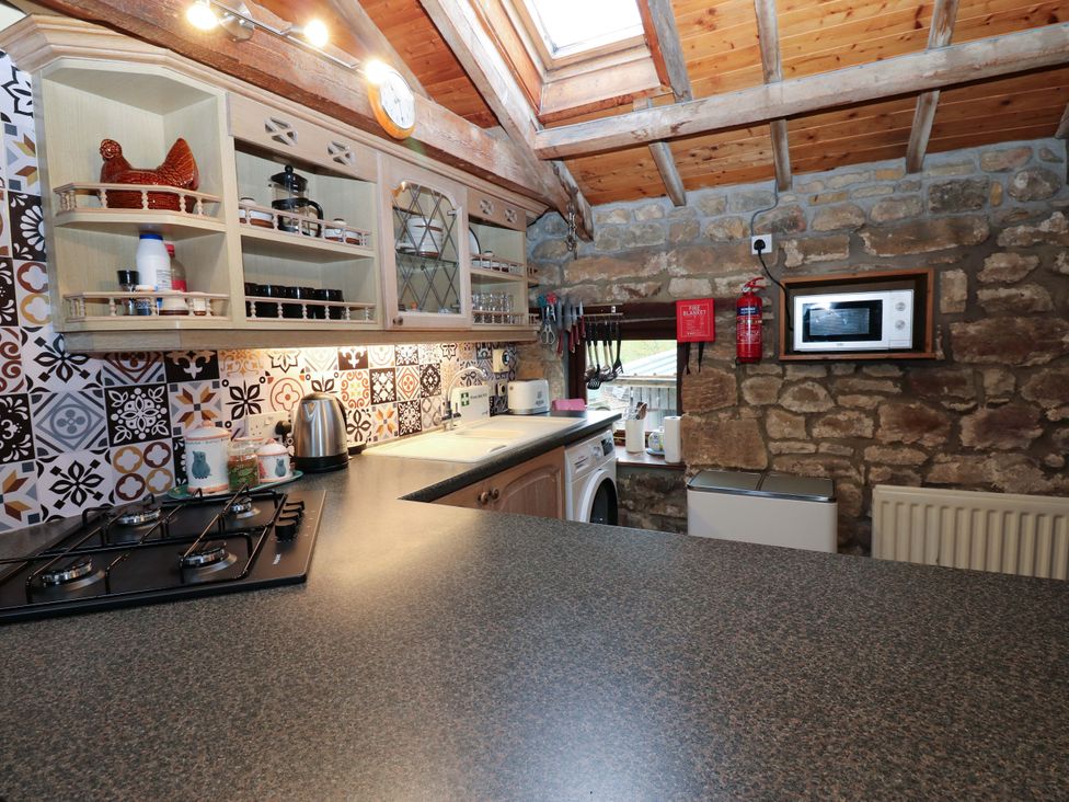 A kitchen with appliances and shelves in The Granary in Rothbury