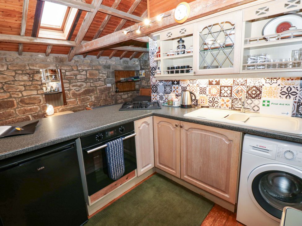 A kitchen with appliances and stone walls at The Granary in Rothbury
