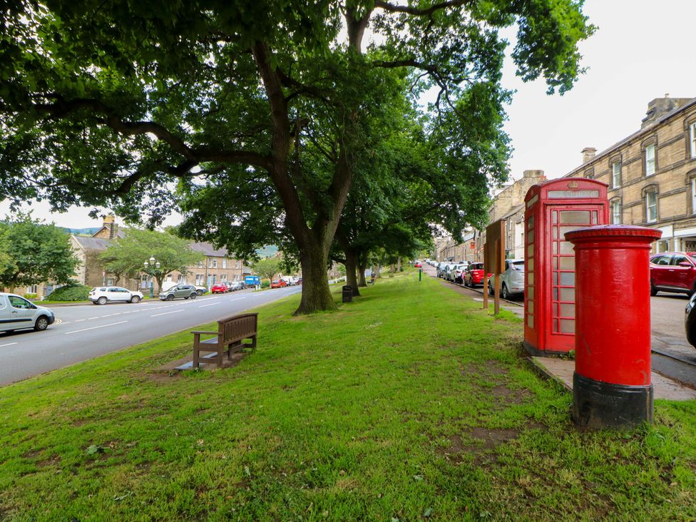 A park area with a telephone box and post box at The Granary in Rothbury