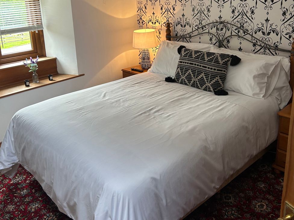 A bedroom with a bed and window at Swaledale Watch Garden Annexe Caldbeck