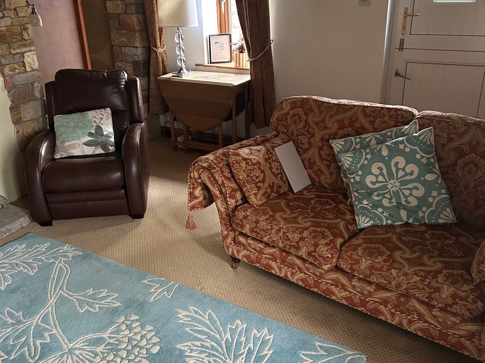 A living room with seating and a table at Swaledale Watch Garden Annexe in Caldbeck