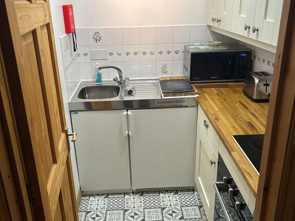 A kitchen with a sink and cabinets at Swaledale Watch Garden Annexe in Caldbeck