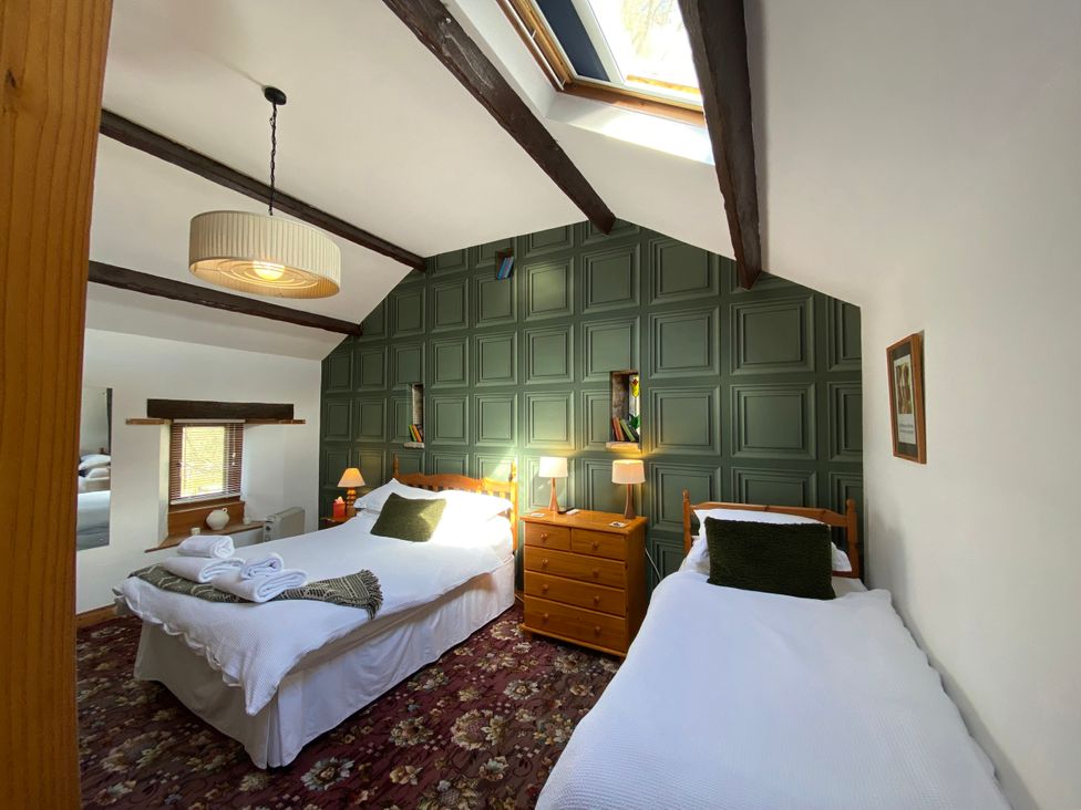 A bedroom with two beds and a dresser at Swaledale Watch Garden Annexe Caldbeck