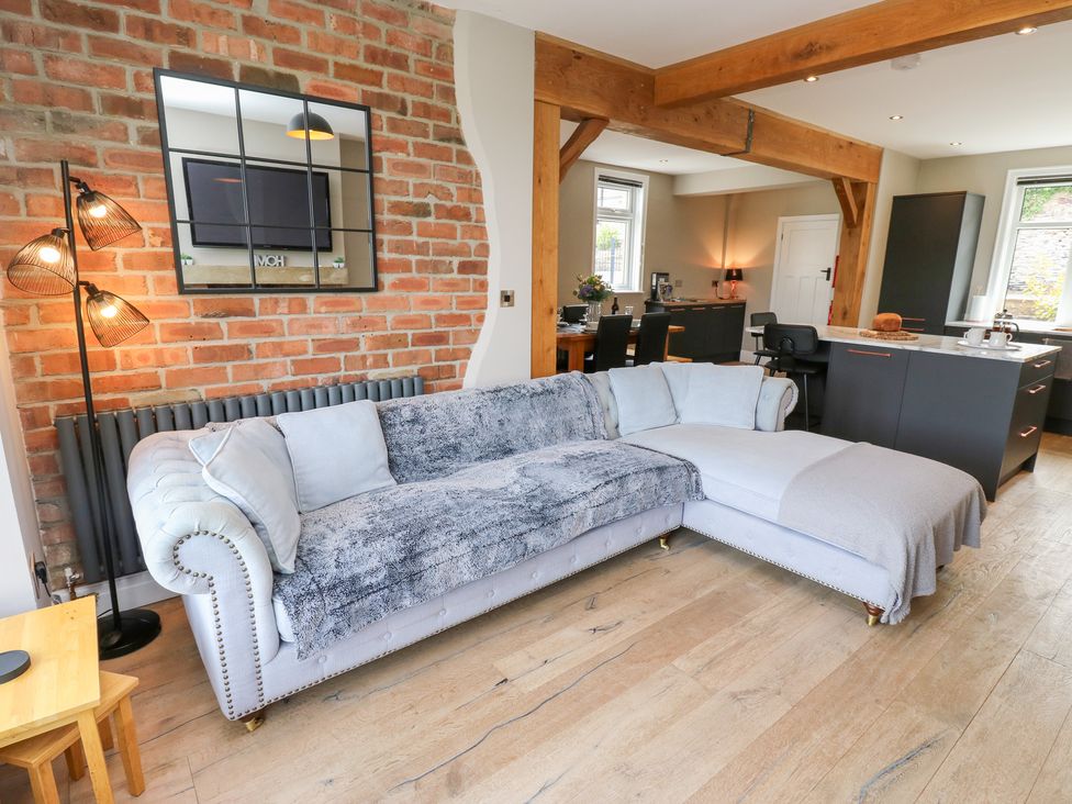 A living room with a sofa and lamp at Farnhill View in Cross Hills