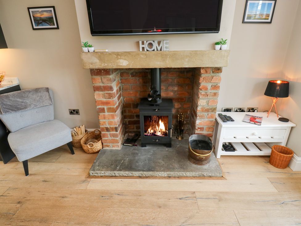 A living room with a fireplace and television at Farnhill View in Cross Hills
