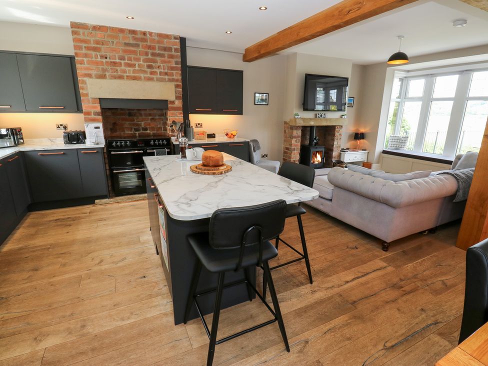 A kitchen with an island and stove at Farnhill View in Cross Hills