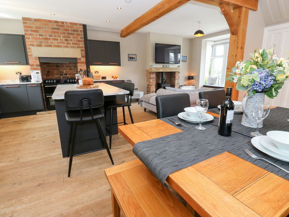 A kitchen with dining area and a fireplace at Farnhill View in Cross Hills