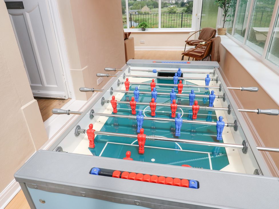 A foosball table with red and blue players at Farnhill View Cross Hills