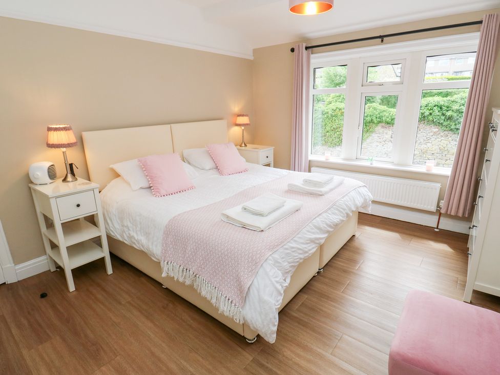 A bedroom with a bed and nightstands at Farnhill View in Cross Hills