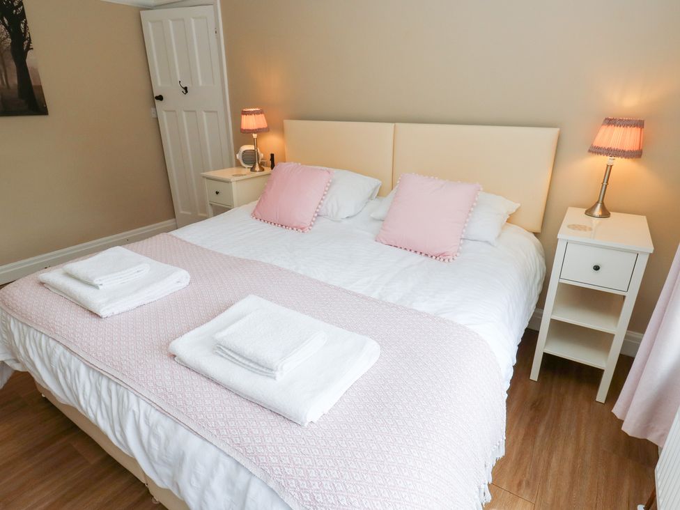 A bedroom with a bed and nightstand at Farnhill View, Cross Hills