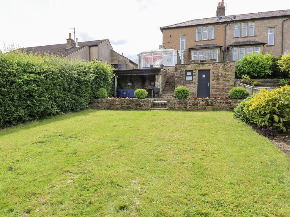 A garden with stone steps and a patio area at Farnhill View in Cross Hills