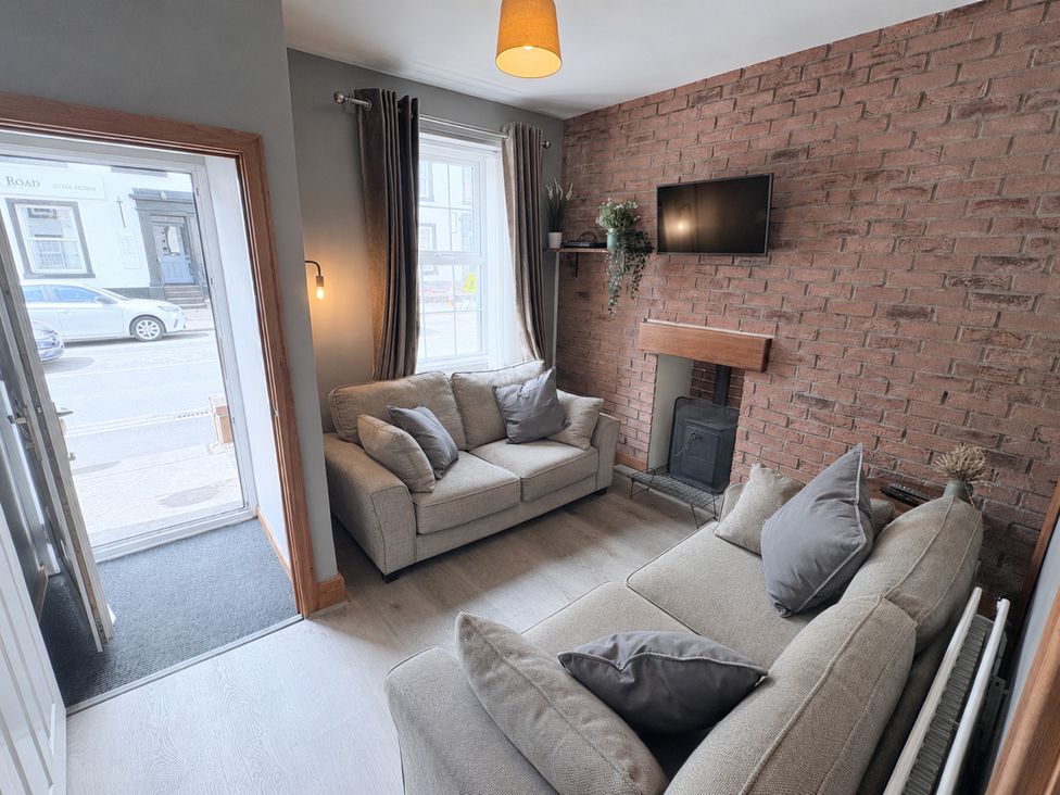 A living room with a sofa and television at The Oaks Cottage in Penrith