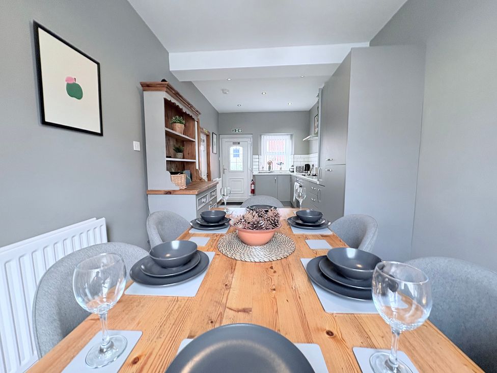A dining room with a wooden table set for dining at The Oaks Cottage Penrith