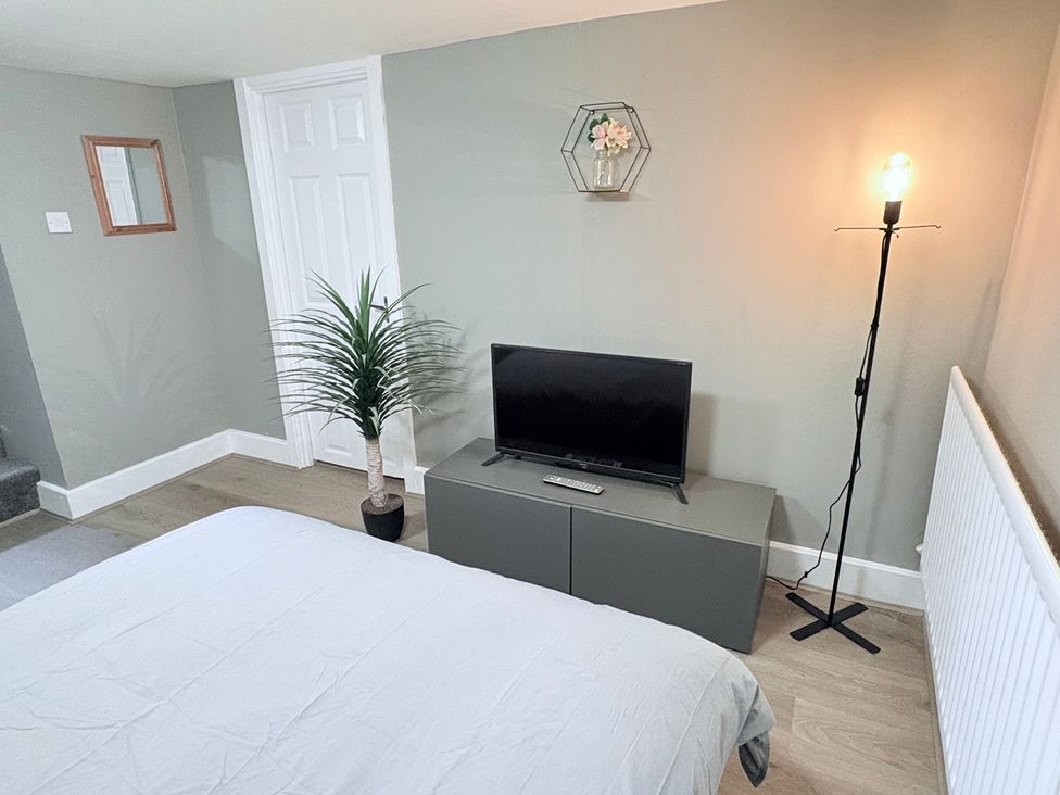 A bedroom with a television and plant at The Oaks Cottage Penrith