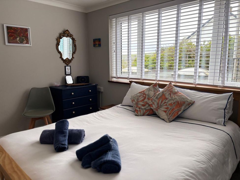 A bedroom with a bed and dresser at Stonecroft in Praa Sands